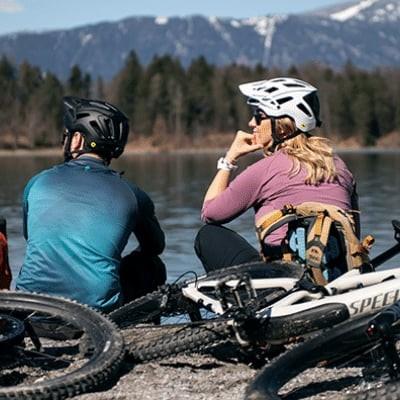Zwei Radfahrer am See mit Specialized E-Bikes vor Bergkulisse