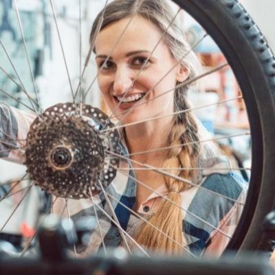 Frau überprüft Fahrradreifen in Werkstatt