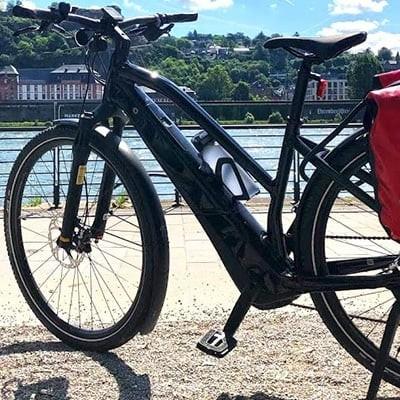Specialized Vado 5.0 E-Bike mit Gepäcktaschen vor Flusslandschaft