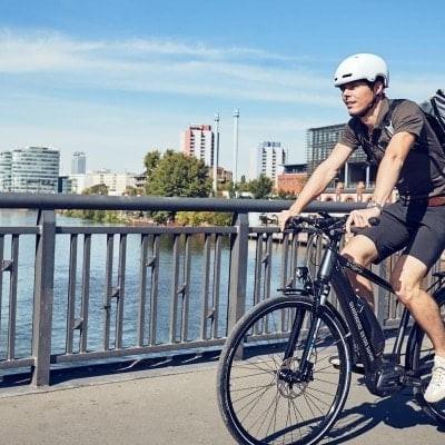 Mann auf Shimano Steps E-Bike fährt über Brücke in urbaner Umgebung