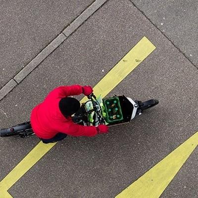 Luftaufnahme eines Packster E-Bikes mit Getränkekiste auf Asphalt