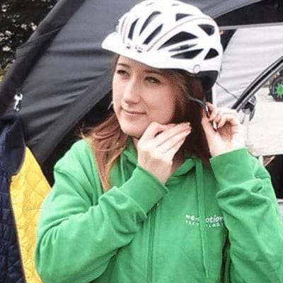 Frau mit Helm vor einem Zelt bei einer Veranstaltung