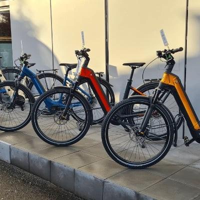 Mehrere E-Bikes verschiedener Marken auf einem Gehweg ausgestellt