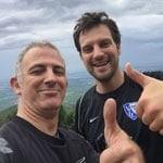 Zwei Männer lächeln und zeigen Daumen hoch im Freien