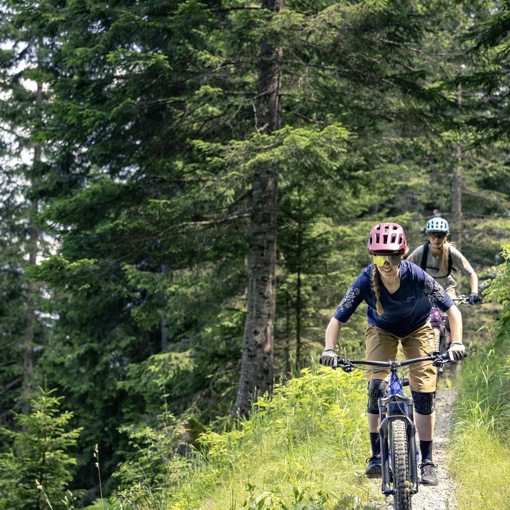 Zwei Personen fahren mit Bosch E-Bikes auf einem Waldpfad. Perfekt für abenteuerliche Touren in der Natur.