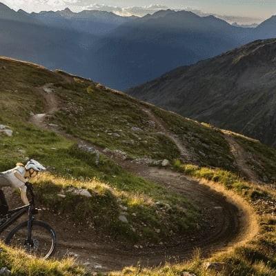 Mountainbiker auf Specialized Levo SL auf alpinem Trail bei Sonnenuntergang