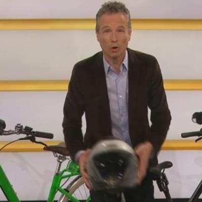 Moderator mit E-Bikes und Helmen im Studio