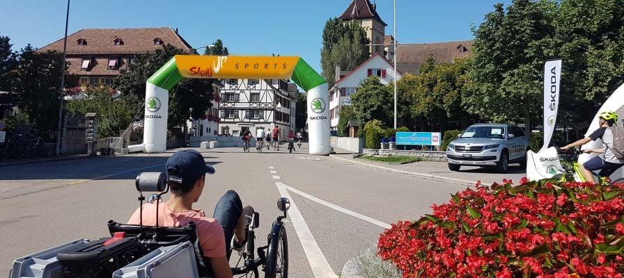 Veranstaltung mit Skoda-Banner und Liegeradfahrer auf Stadtstraße