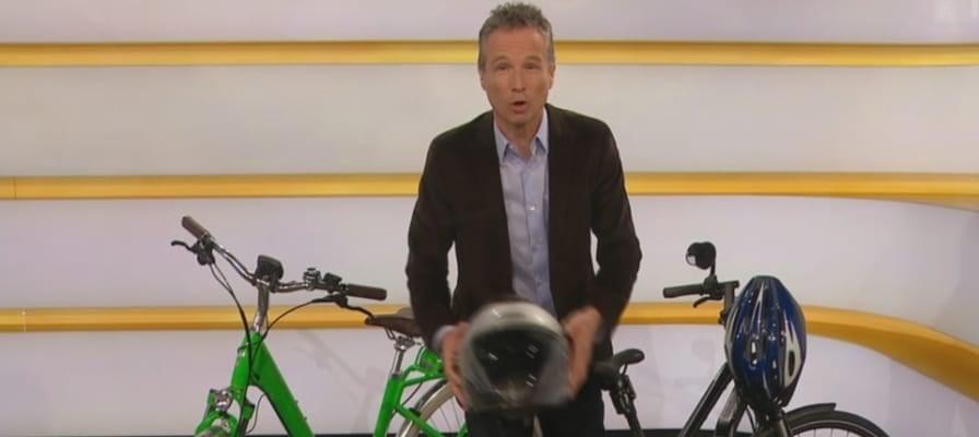Moderator mit E-Bikes und Helmen im Studio