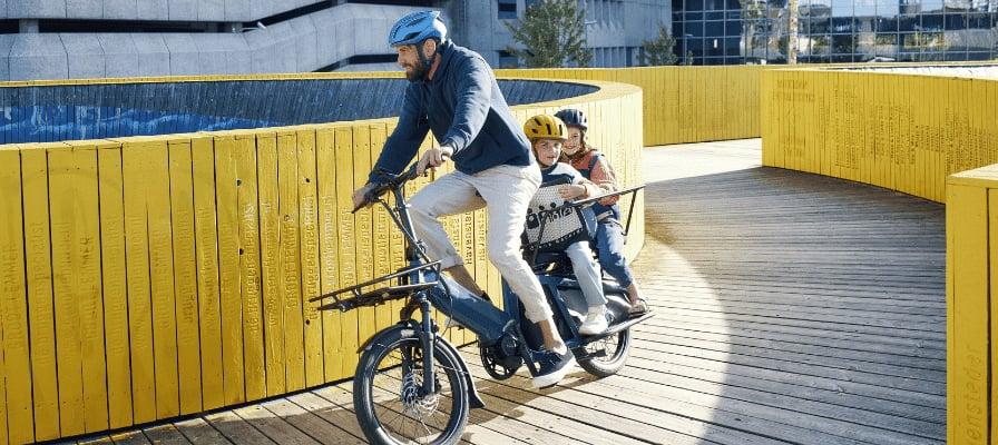Riese & Müller Multitinker E-Bike mit zwei Personen auf Holzweg