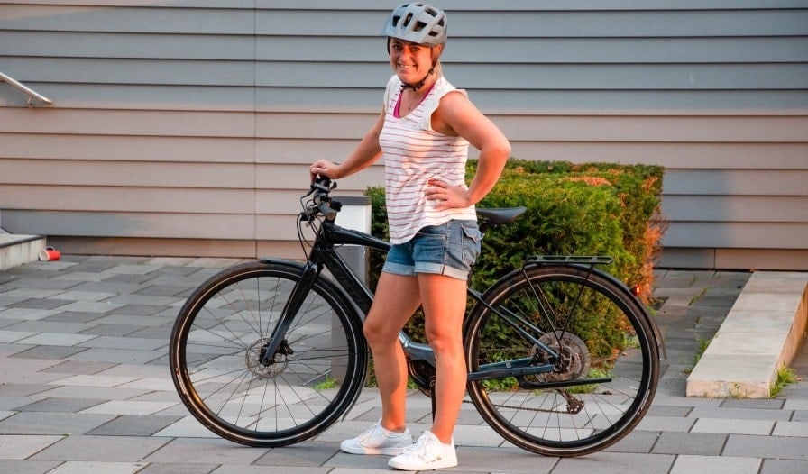 Frau mit Specialized Vado SL E-Bike auf gepflastertem Weg