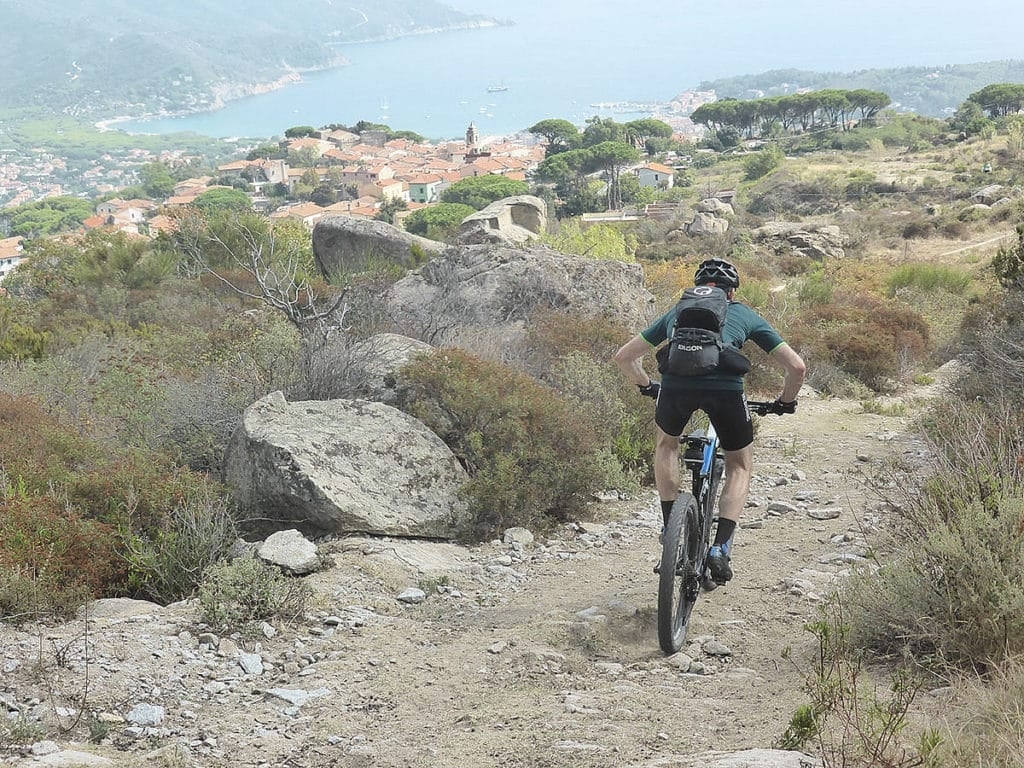 E-Bike-Fahrer auf steinigem Pfad mit Küstenblick