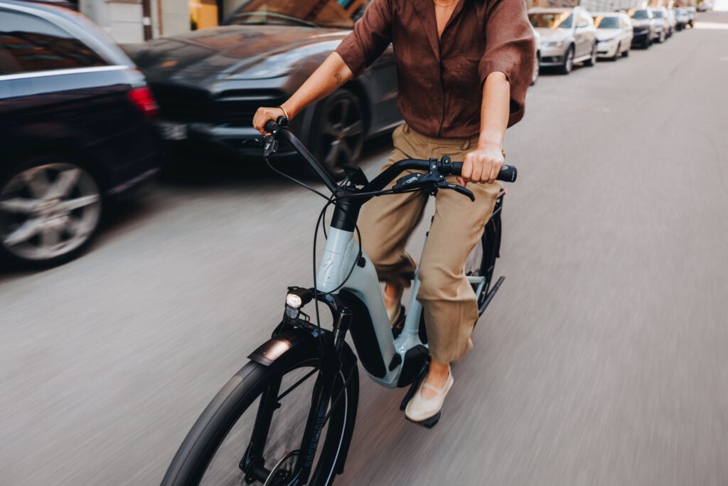 Person auf E-Bike fährt durch Stadtstraße