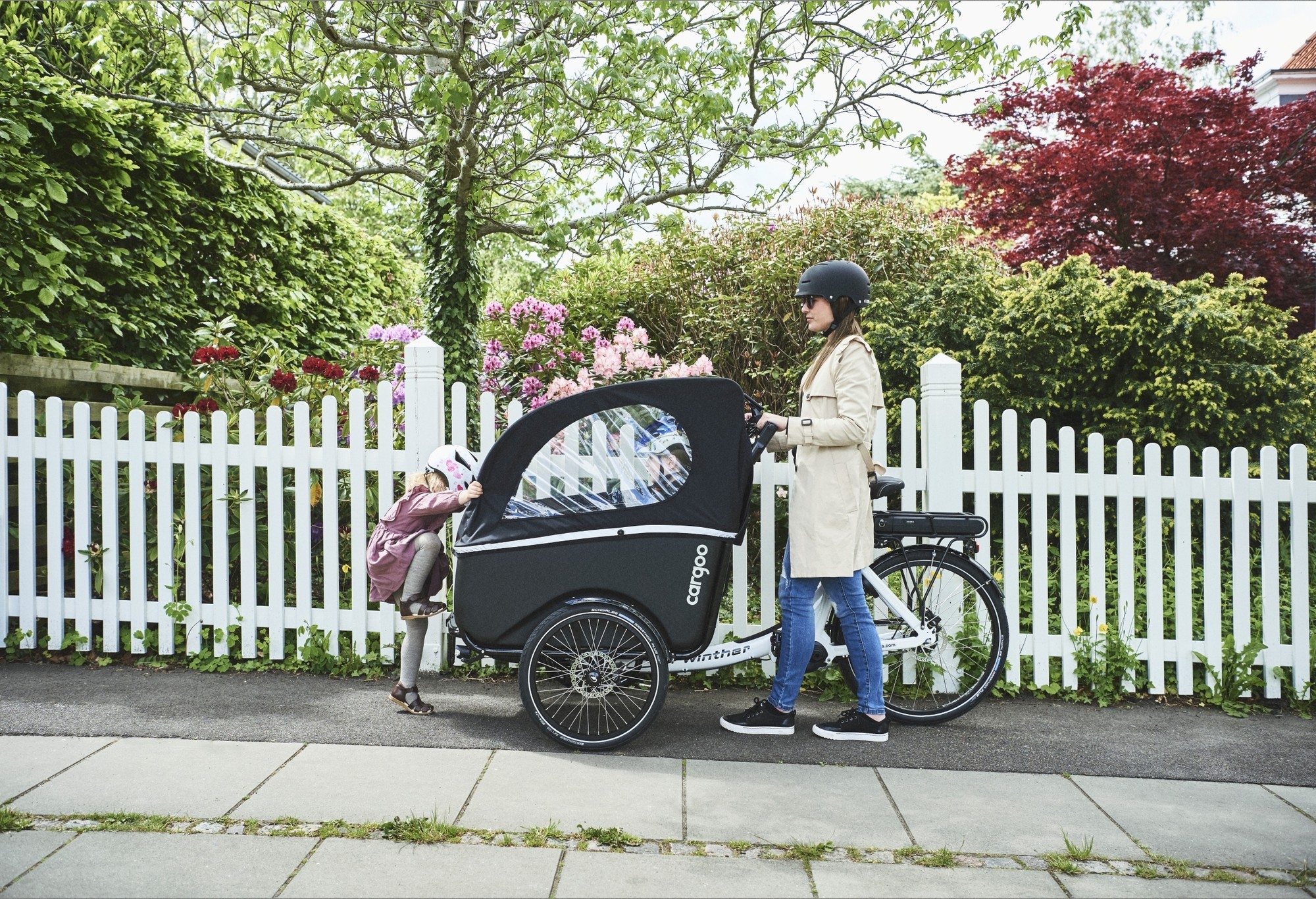 Das Bild zeigt ein Winther Cargoo Kangaroo, ein E-Bike, das mit einem innovativen Kinderanhänger ausgestattet ist.