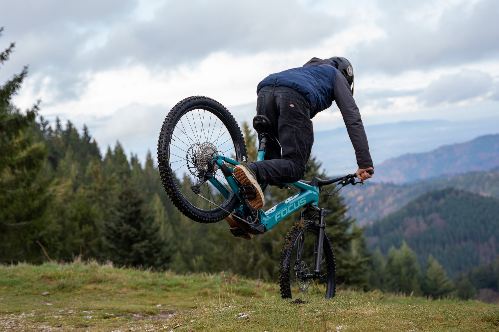 Das Bild zeigt einen Fahrer, der mit einem Focus Jam 7.8 E-Bike einen beeindruckenden Trick in der Natur ausführt.