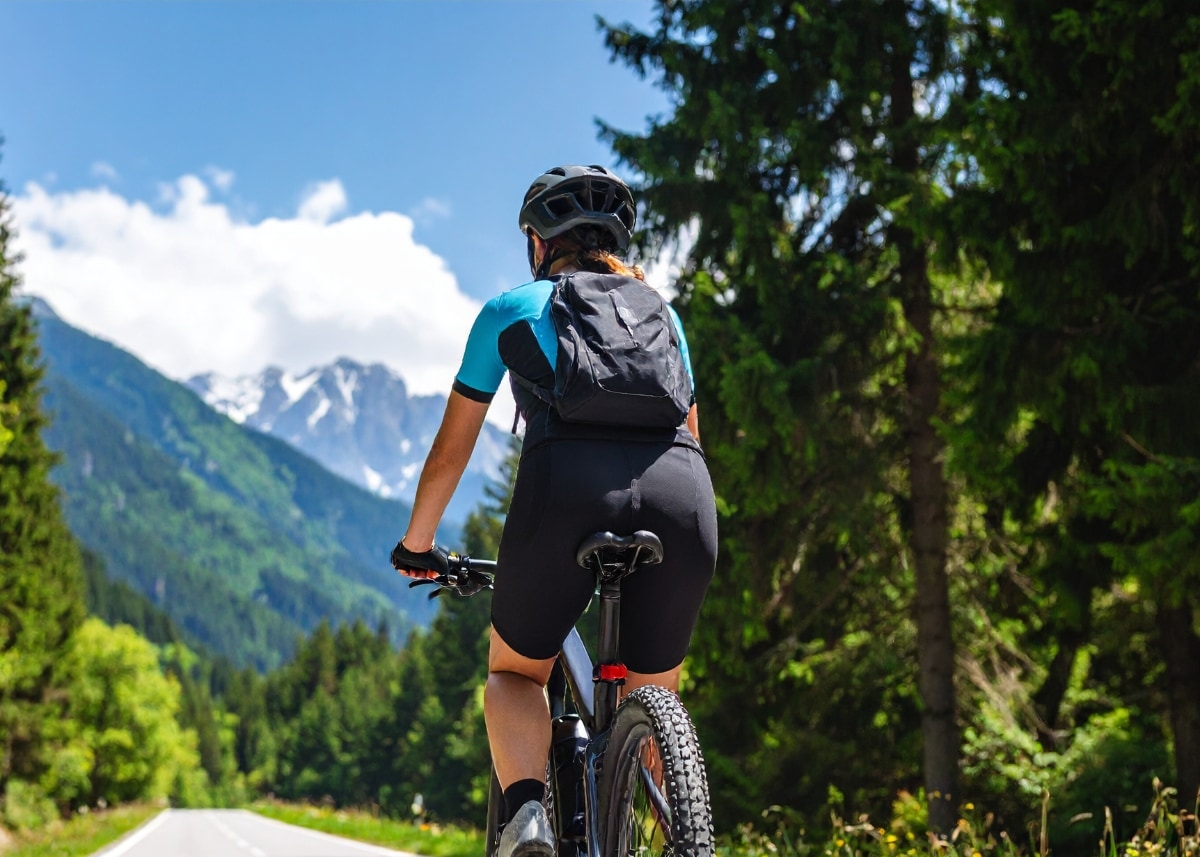 Ein Radfahrer genießt eine Fahrt durch eine atemberaubende Berglandschaft. Perfekt für Outdoor-Enthusiasten, die Na