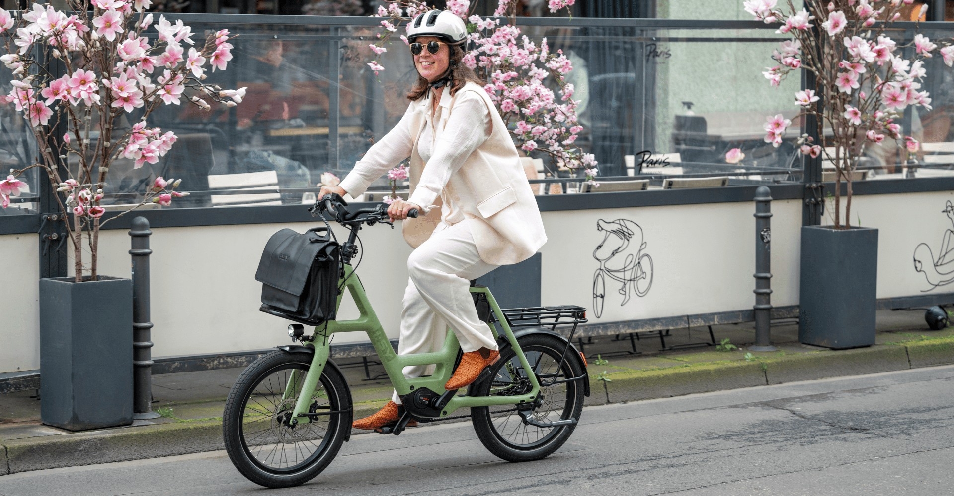 Eine Frau fährt auf einem grünen i:SY Kompakt e-Bike