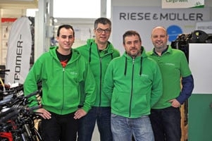 Team in grünen Hoodies vor E-Bike-Markenwerbung bei e-motion e-Bike Welt Dietikon