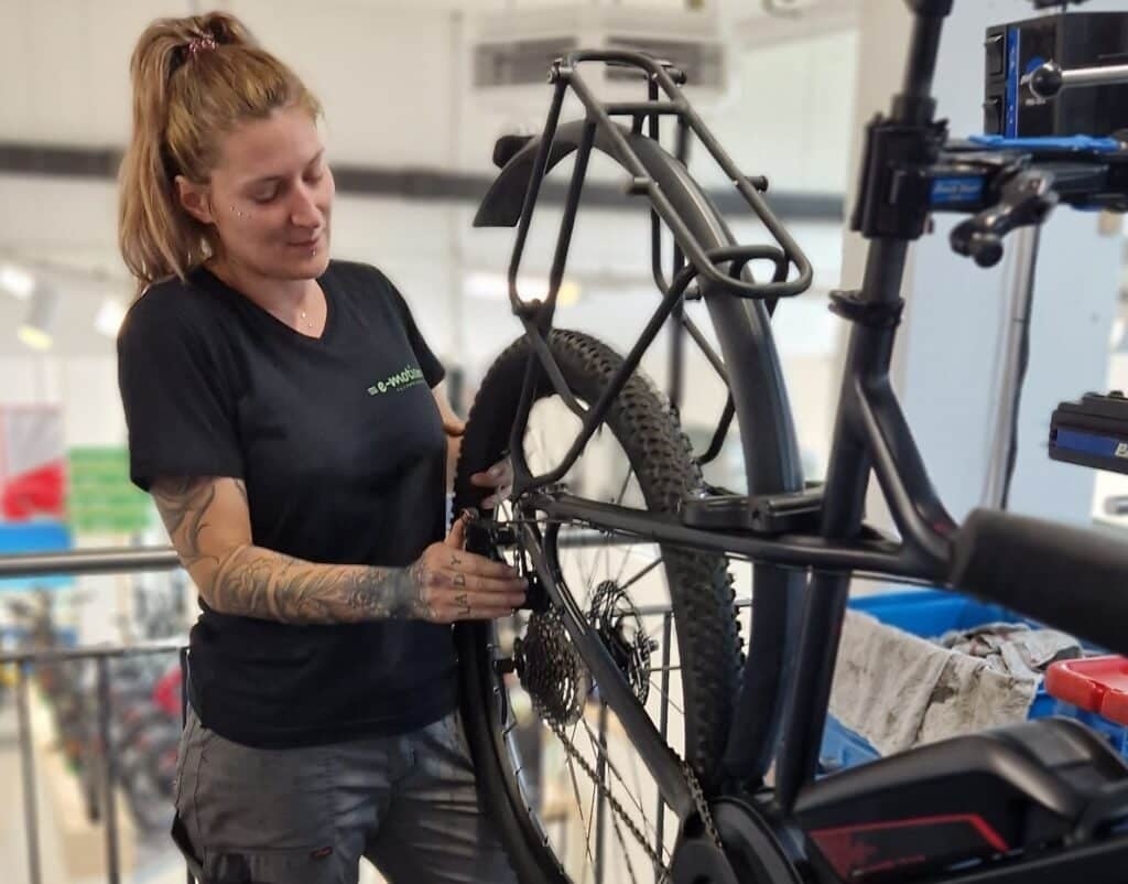 Mechanikerin repariert E-Bike in Werkstatt mit Shimano-Komponenten