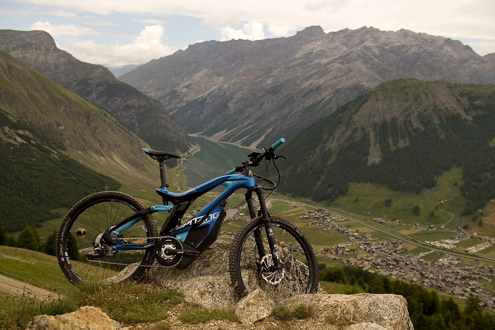 Das Bild zeigt ein E-Bike des Modells M1 Spitzing, das auf einem steinigen Untergrund in einer beeindruckenden al..