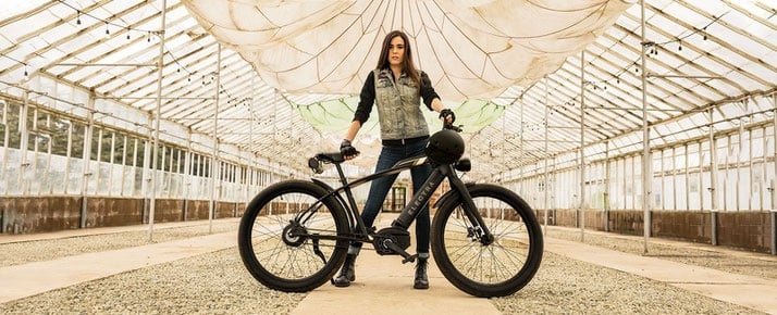 Frau mit E-Bike in Gewächshaus