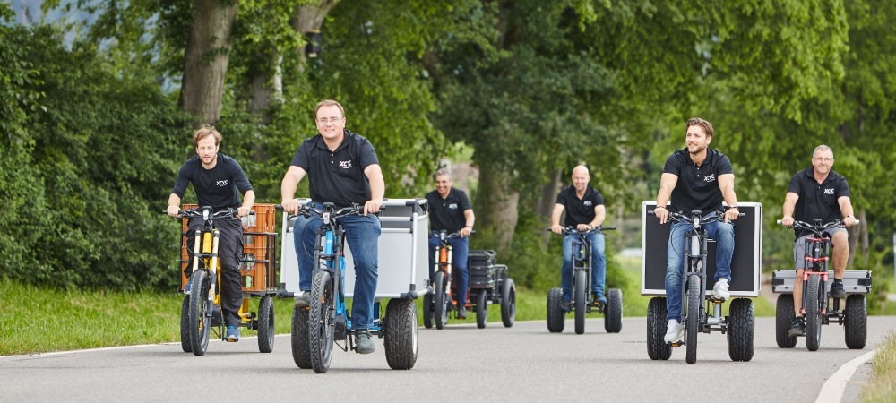 6 Männer fahren auf den XCYC B2B-Lastenrädern die Straße entlang