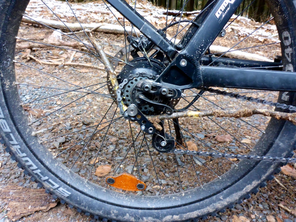 Hinterrad eines E-Bikes mit Schwalbe Reifen und Kettenschaltung. Robustes Design für Offroad-Abenteuer.