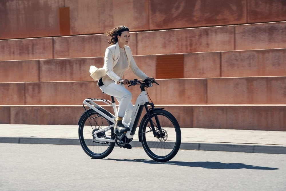 Frau auf Riese & Müller E-Bike vor moderner Architektur