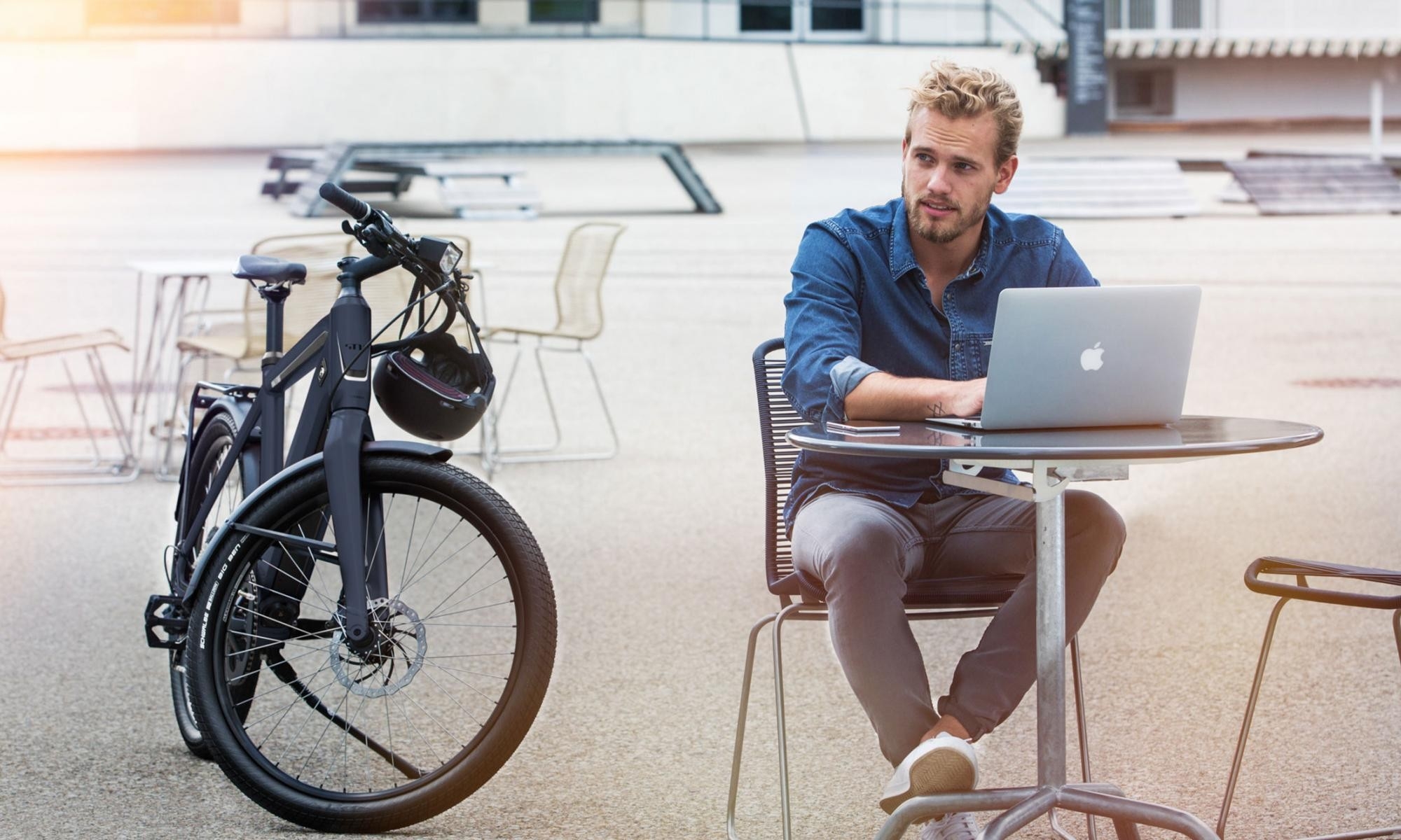 Ein Mann sitzt im Café, neben ihm steht ein Stromer ST1