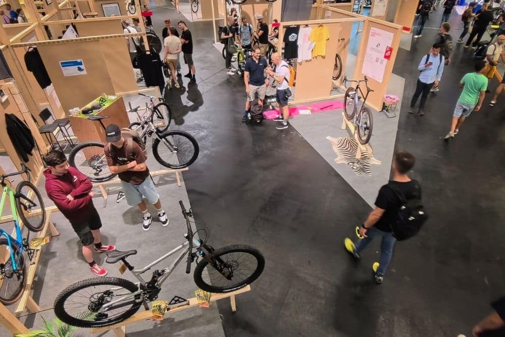 Fahrradmesse: Besucher betrachten verschiedene Fahrräder in einer Ausstellungshalle