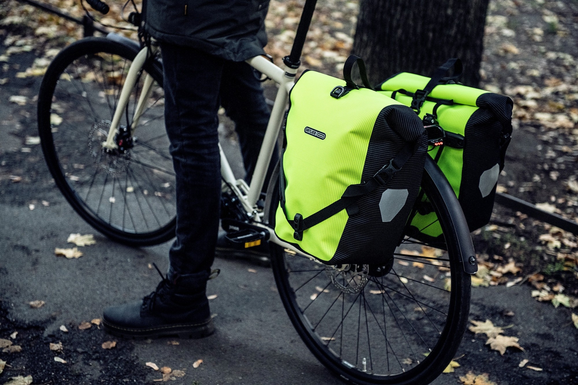 Das Bild zeigt ein Fahrrad, das mit zwei auffÀlligen, leuchtend Ortlieb Back Roller HV Taschen ausgestattet ist.