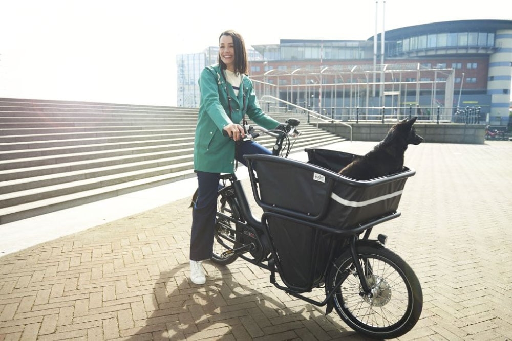 Frau mit Urban Arrow Shorty Lastenrad und Hund im Transportkorb