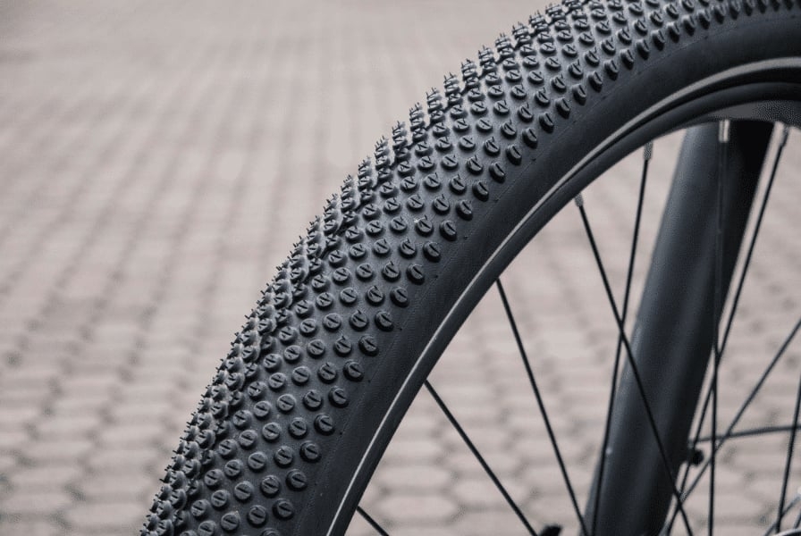 Nahaufnahme eines Gravelbike-Reifens auf gepflastertem Untergrund