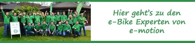 Gruppe von e-Bike-Experten in grüner Kleidung vor Gebäude