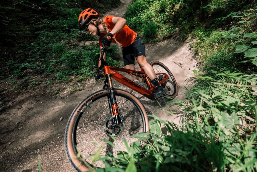 Mountainbikerin auf KTM-Bike in Waldkurve